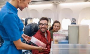 Air hostess offering alcohol for sale to passengers