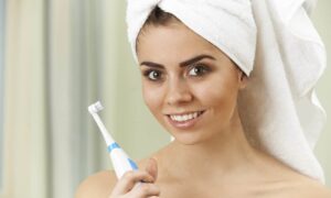 Woman with electric toothbrush