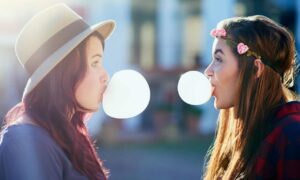 Women blowing bubble gum