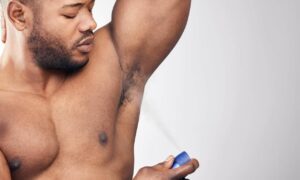 man spraying deodorant