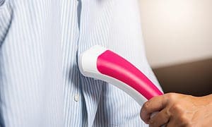 woman using electric hand steamer