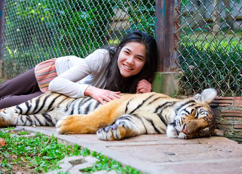 Teen girl playing with tiger cub
