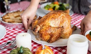 woman preparing turkey for thanksgiving dinner at home kitchen
